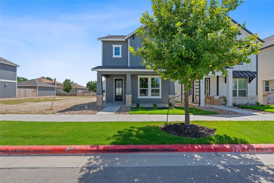 View of front facade featuring a porch, a front lawn, a shingled roof, and board and batten siding
