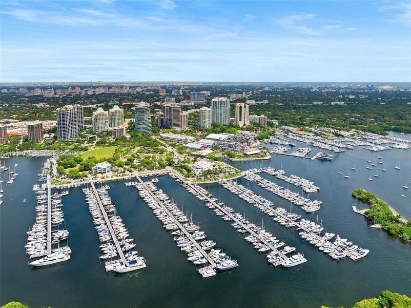 Sweeping aerial view of Dinner Key Marina, Biscayne Bay, and Coconut Grove skyline—steps from waterfront parks and boating lifestyle.