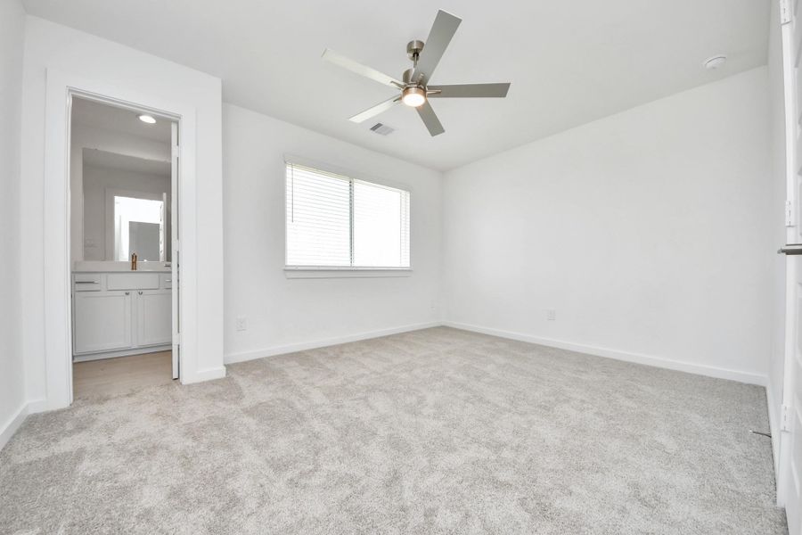 Secondary bedroom features plush carpeting, large windows that let in plenty of natural light, bright paint, and spacious closets.