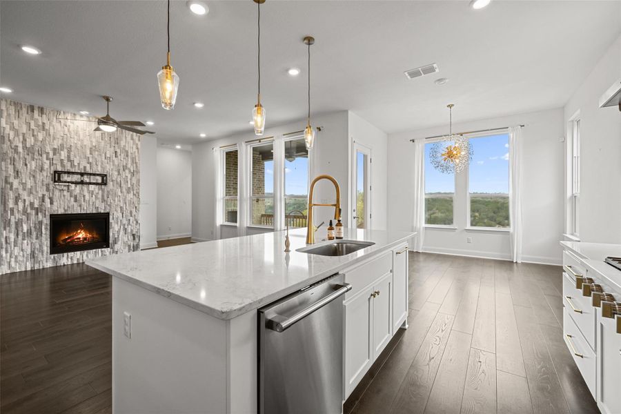 Kitchen featuring visible vents, dark wood-type flooring, a sink, ceiling fan with notable chandelier, and stainless steel dishwasher