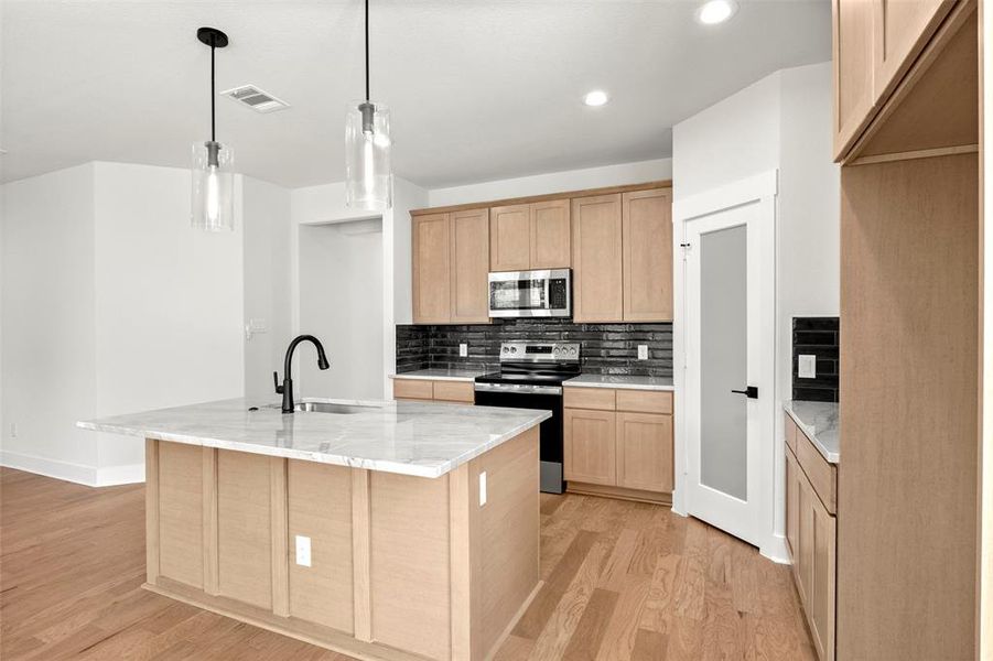 Kitchen with tasteful backsplash, stainless steel appliances, pendant lighting, light wood-type flooring, and recessed lighting