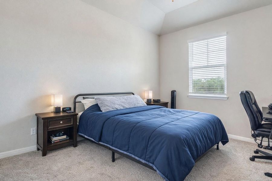 The 4th bedroom  showcasing ample floor space, soft carpeting, and a sun-filled window for natural light.