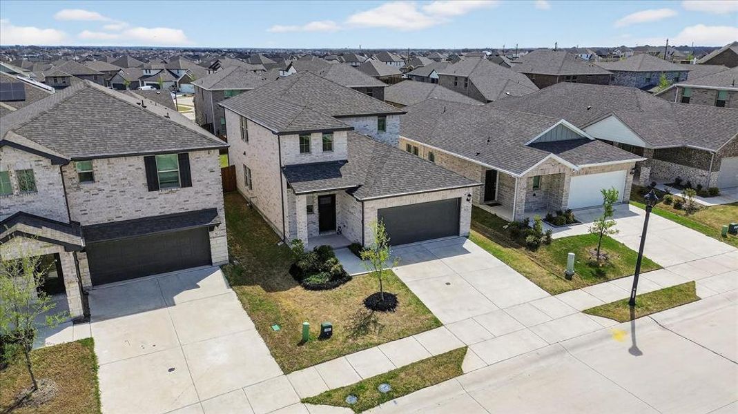 View of front of home featuring driveway, a residential view, and a shingled roof