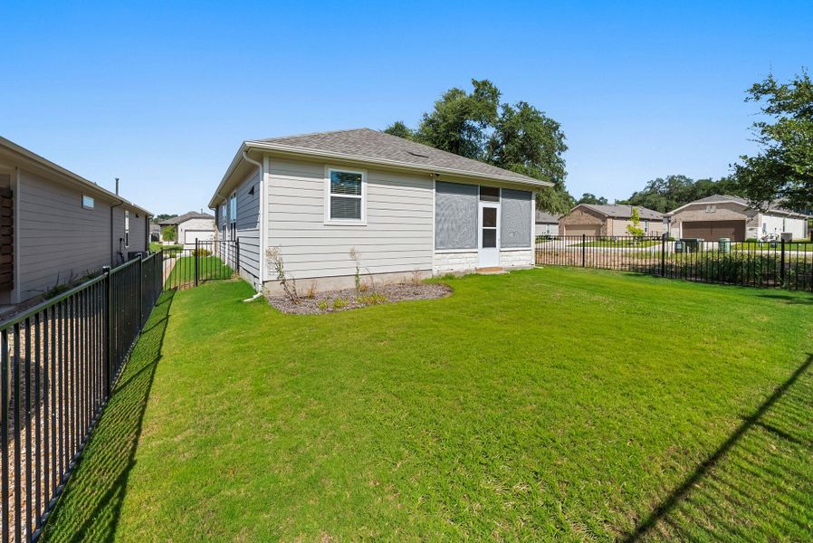A well-maintained lawn stretches beside a contemporary home with a screened-in porch, framed by a sturdy black fence. A well-maintained lawn stretches beside a contemporary home with a screened-in porch, framed by a sturdy black fence.