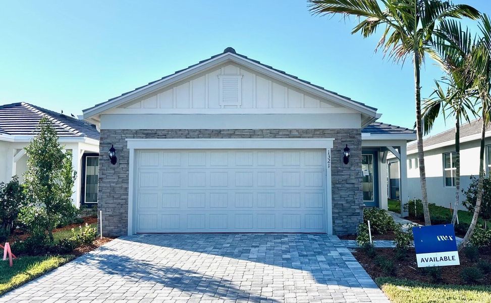 Front exterior of a new home in Costa Pointe, Vero Beach, FL, highlighting curb appeal (Image 1).