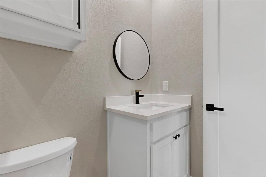 Bathroom featuring a textured wall and vanity Bathroom featuring a textured wall and vanity