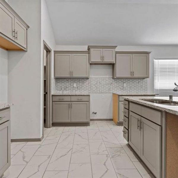 Another view of the kitchen, note the granite countertops, abundance of cabinet space and lofty ceilings. **This image is from another Saratoga Home with similar floor plan - Myrtle Floorplan.**