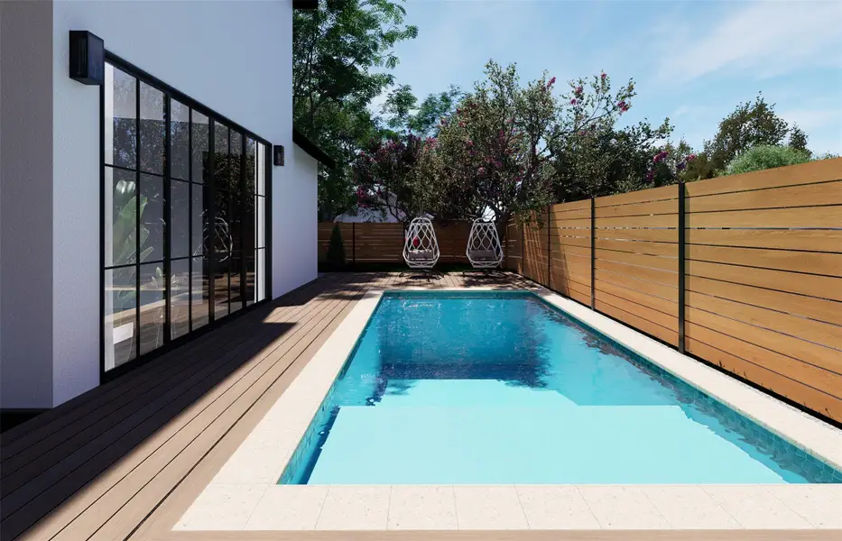 An inviting backyard pool is bordered by composite decking, wooden fencing, and mature trees. An inviting backyard pool is bordered by composite decking, wooden fencing, and mature trees.