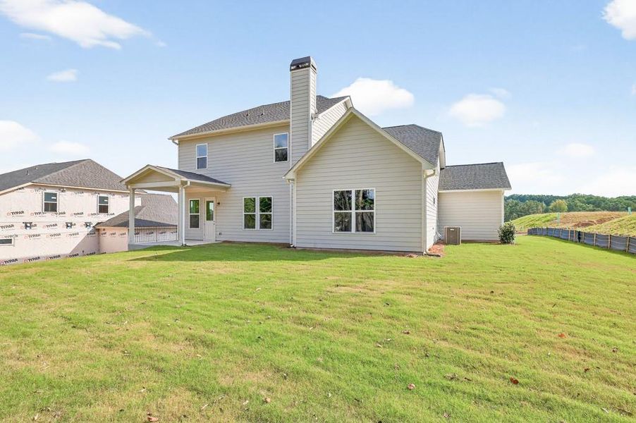 Front exterior of a new home in Traditions of Braselton, Hoschton, GA, highlighting curb appeal (Image 1).