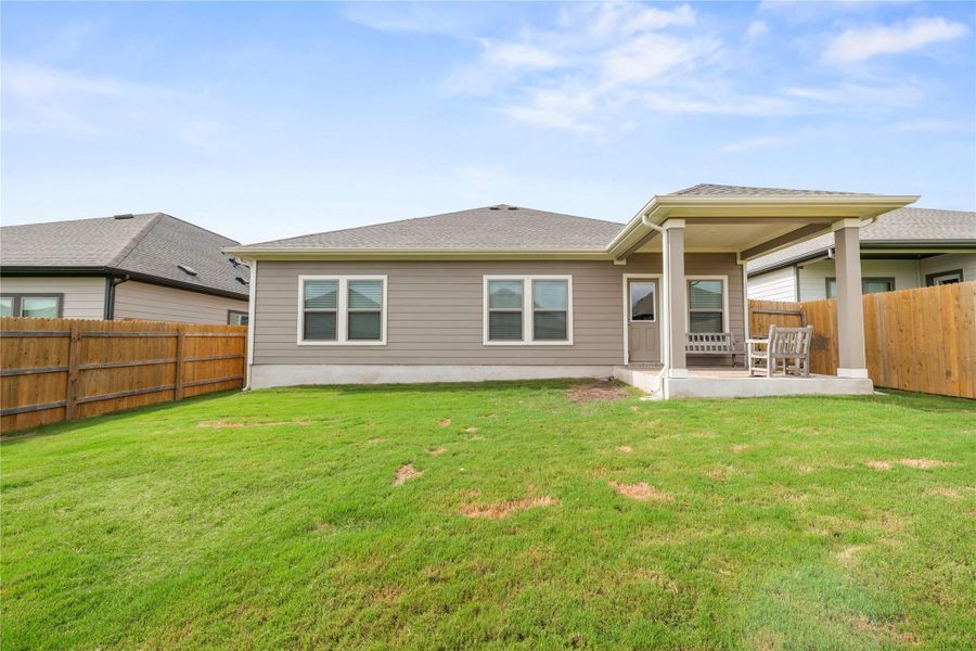 A spacious yard provides ample room for outdoor activities, complemented by a covered patio for shaded enjoyment. A spacious yard provides ample room for outdoor activities, complemented by a covered patio for shaded enjoyment.