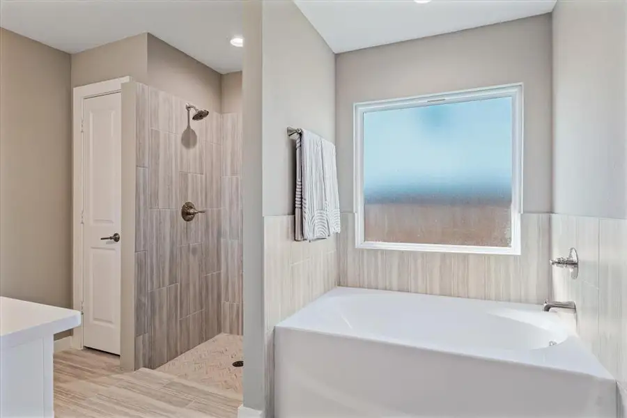 Bathroom featuring separate shower and tub, hardwood / wood-style floors, and a healthy amount of sunlight