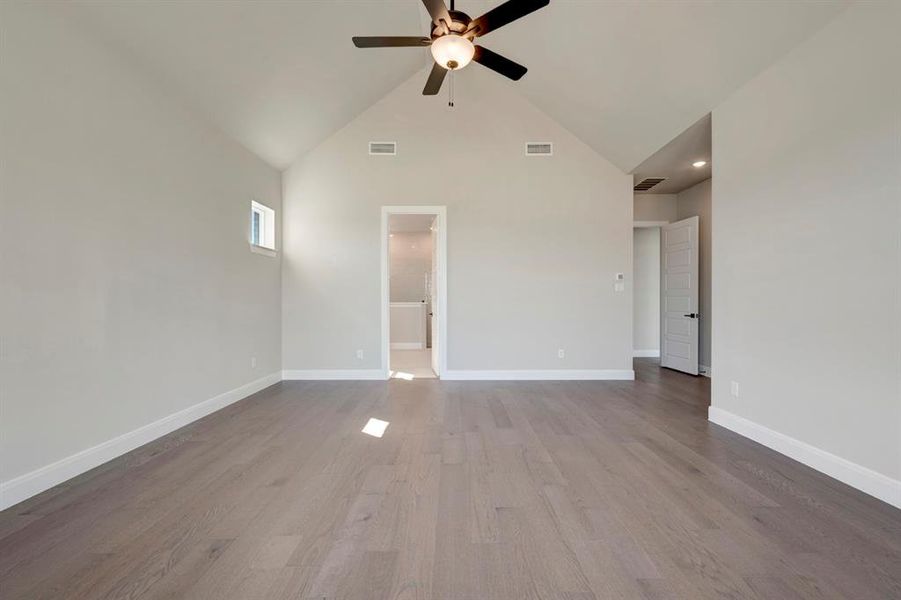 Unfurnished living room featuring dark wood-style flooring, vaulted ceiling, and ceiling fan Unfurnished living room featuring dark wood-style flooring, vaulted ceiling, and ceiling fan