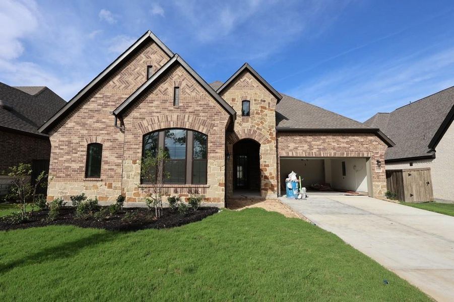Front exterior of a new home in Riceland 60’ Homesites, Mont Belvieu, TX, highlighting curb appeal (Image 20). Front exterior of a new home in Riceland 60’ Homesites, Mont Belvieu, TX, highlighting curb appeal (Image 20).