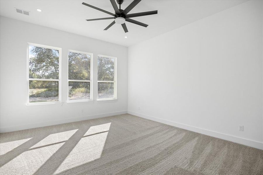 Spacious Owners room featuring three large windows, recessed lighting, and a modern black ceiling fan