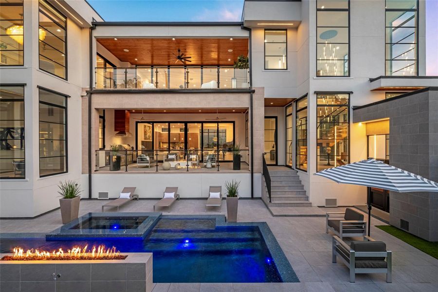 Collaborative efforts and exquisite, contemporary design presented by SJS Development. Outdoor living with a pool and elevated spa, glass-tile finish, pool lighting, and a linear fire feature — all framed by the home's two covered terraces. Collaborative efforts and exquisite, contemporary design presented by SJS Development. Outdoor living with a pool and elevated spa, glass-tile finish, pool lighting, and a linear fire feature — all framed by the home's two covered terraces.