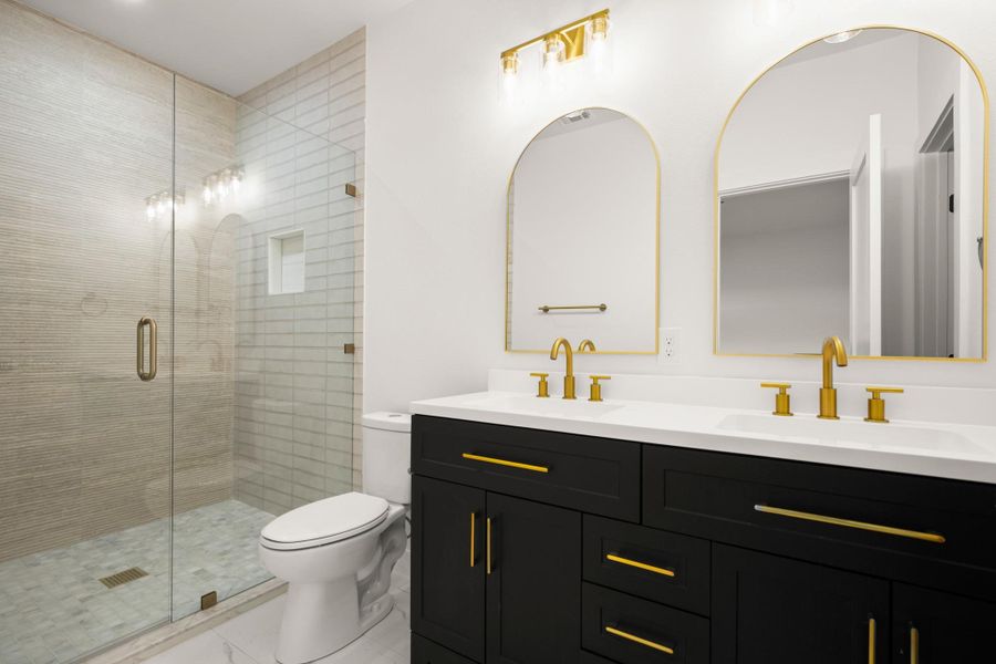 Full bathroom featuring double vanity and a shower stall