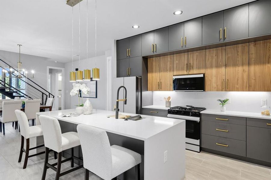 Kitchen with gray cabinetry, a kitchen breakfast bar, black gas range, pendant lighting, and modern cabinets Kitchen with gray cabinetry, a kitchen breakfast bar, black gas range, pendant lighting, and modern cabinets