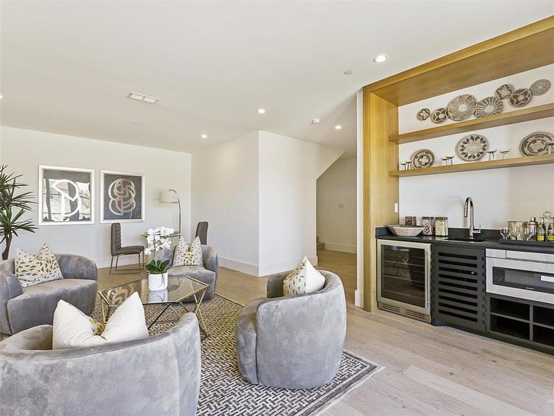 Living room featuring beverage cooler, wet bar, and light hardwood / wood-style floors