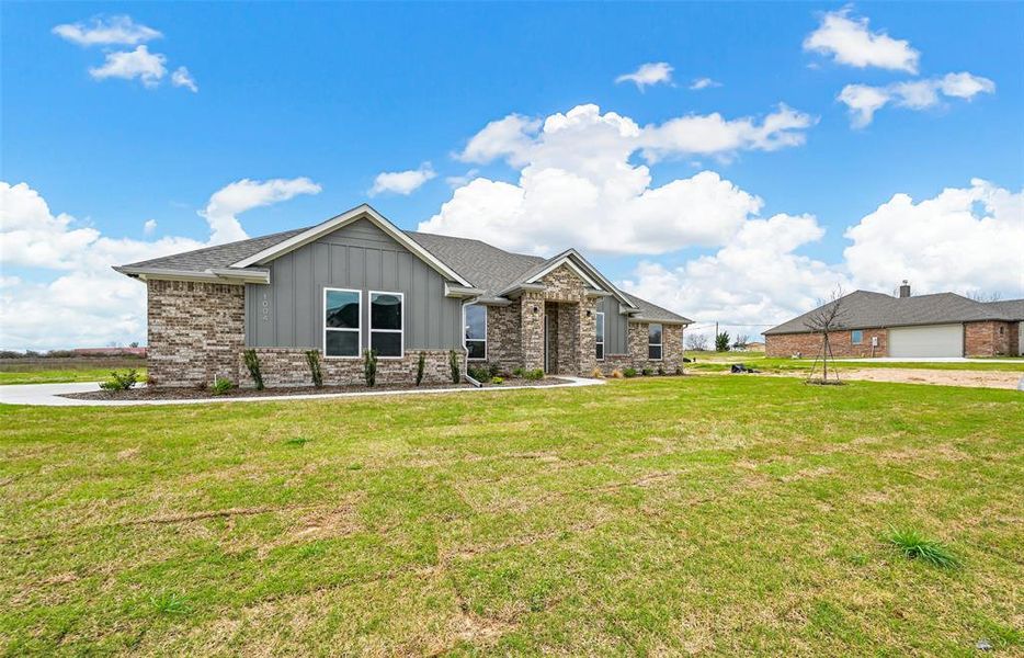 View of front of house with a front yard and a garage