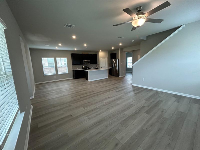 Unfurnished living room with light wood-style flooring, a ceiling fan, and recessed lighting Unfurnished living room with light wood-style flooring, a ceiling fan, and recessed lighting