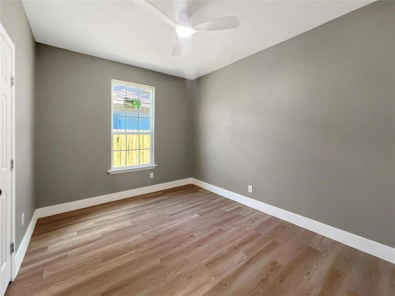 Empty room with ceiling fan and light hardwood / wood-style floors