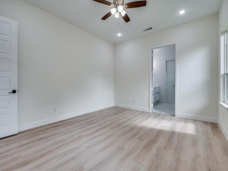 Unfurnished bedroom with light wood-style floors, recessed lighting, baseboards, and connected bathroom