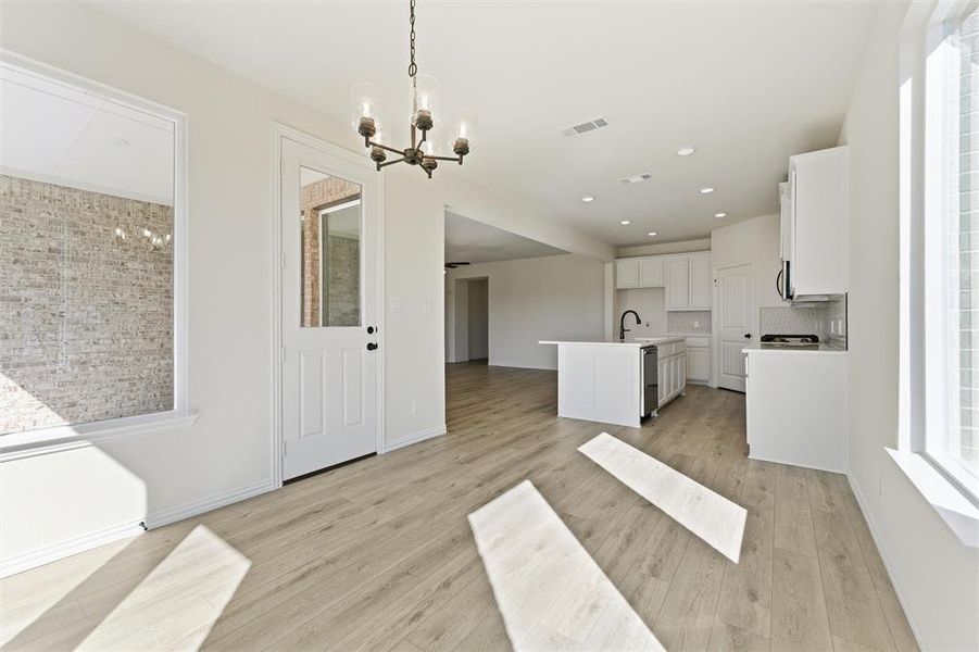Unfurnished dining area with recessed lighting, light wood-style flooring, and a chandelier