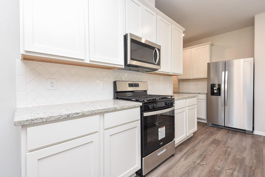 The tried and true use of primarily white kitchen decor works perfectly; with durable granite countertops and sleek white tile backsplash. The tried and true use of primarily white kitchen decor works perfectly; with durable granite countertops and sleek white tile backsplash.