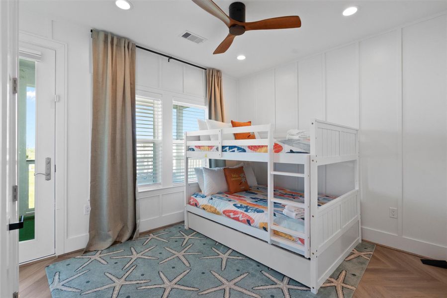 Tucked on the second floor, this versatile bedroom is thoughtfully designed for elevated comfort—featuring a stylish bunk bed with trundle for added sleeping space, a rich wood-accented ceiling fan, and sunlit windows that enhance its bright, coastal charm. A perfect blend of functionality and refined style. Tucked on the second floor, this versatile bedroom is thoughtfully designed for elevated comfort—featuring a stylish bunk bed with trundle for added sleeping space, a rich wood-accented ceiling fan, and sunlit windows that enhance its bright, coastal charm. A perfect blend of functionality and refined style.