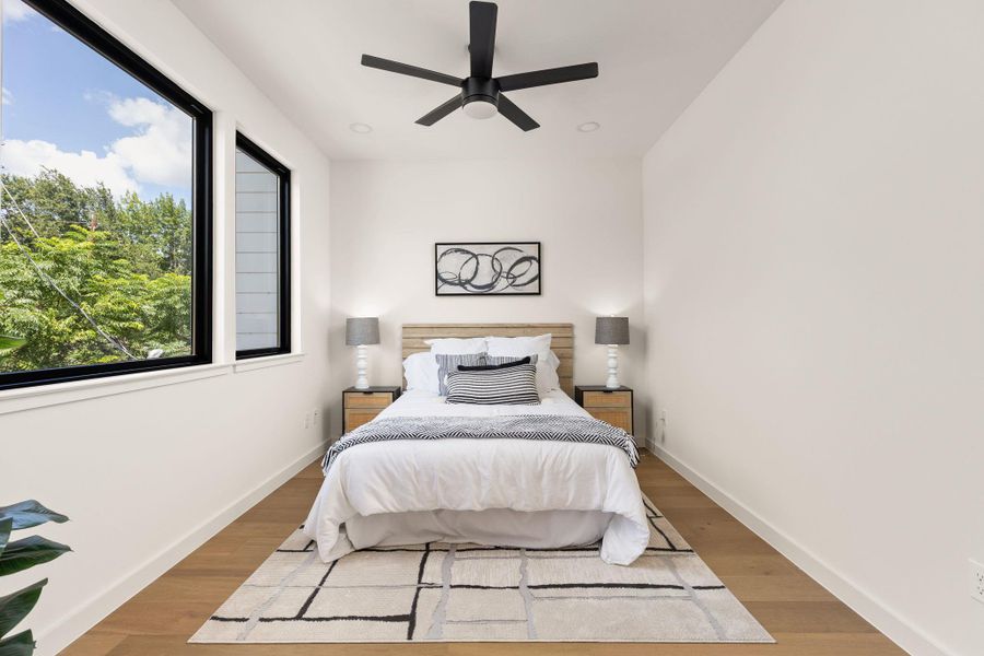 An inviting room with bright windows and warm wood flooring.