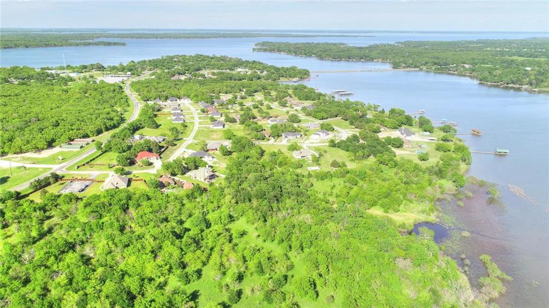 Aerial overview of property's location featuring a nearby body of water and a heavily wooded area Aerial overview of property's location featuring a nearby body of water and a heavily wooded area