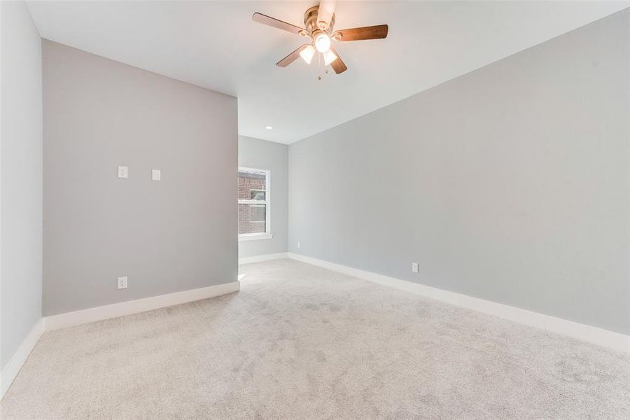 Unfurnished room featuring ceiling fan and light carpet