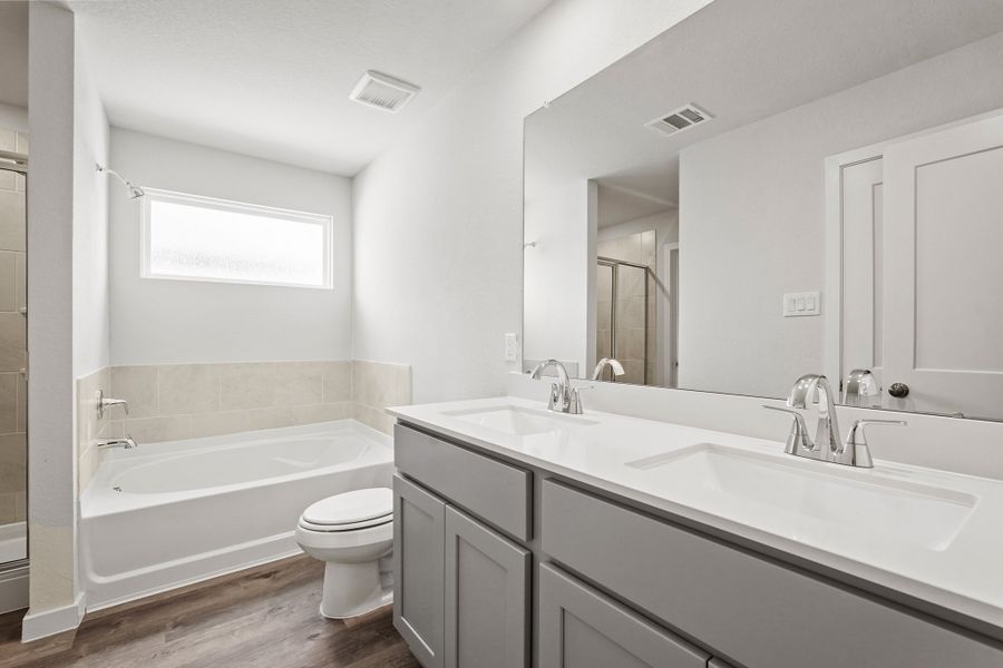 A bathroom with a tub sink and toilet.