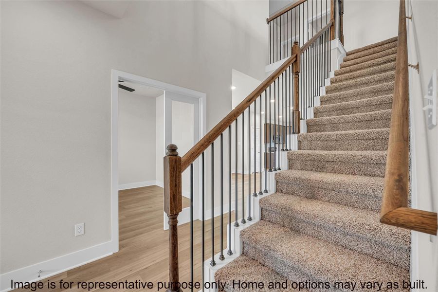 Stairway with wood finished floors and a high ceiling