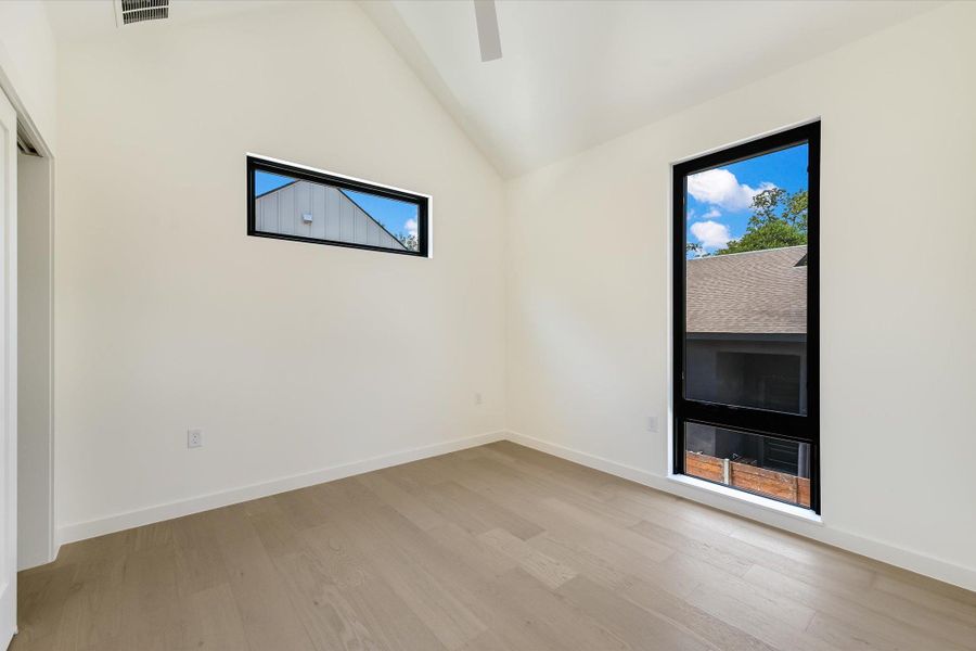 Empty room featuring light wood-style floors and high vaulted ceiling