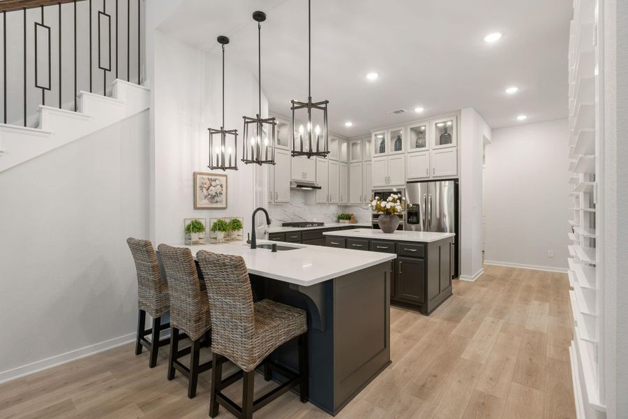 View of the breakfast area and kitchen - abundance of lighting including pendant lights and upper cabinet lighting.