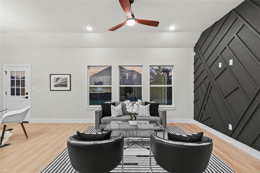 Living room with ceiling fan, hardwood / wood-style floors, and lofted ceiling