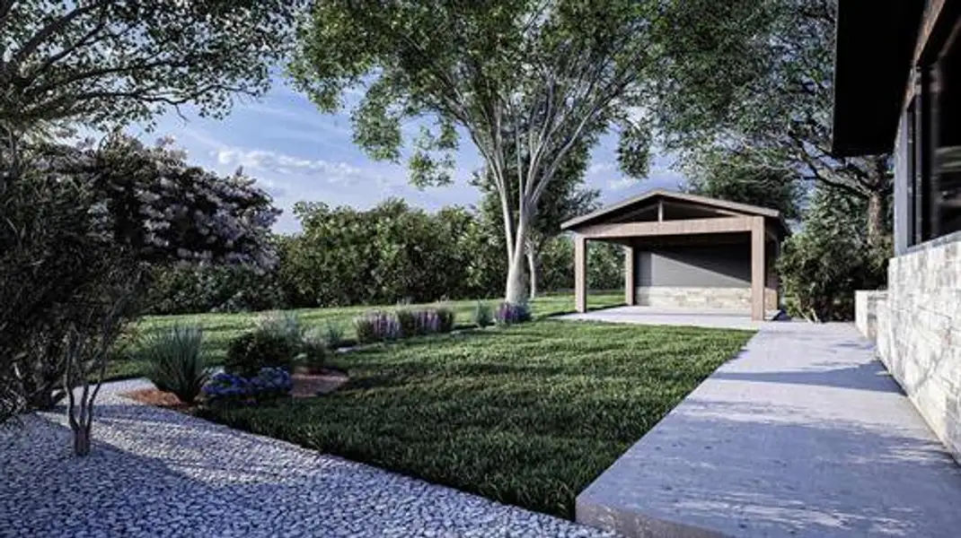 View of green lawn featuring view of wooded area and an outbuilding