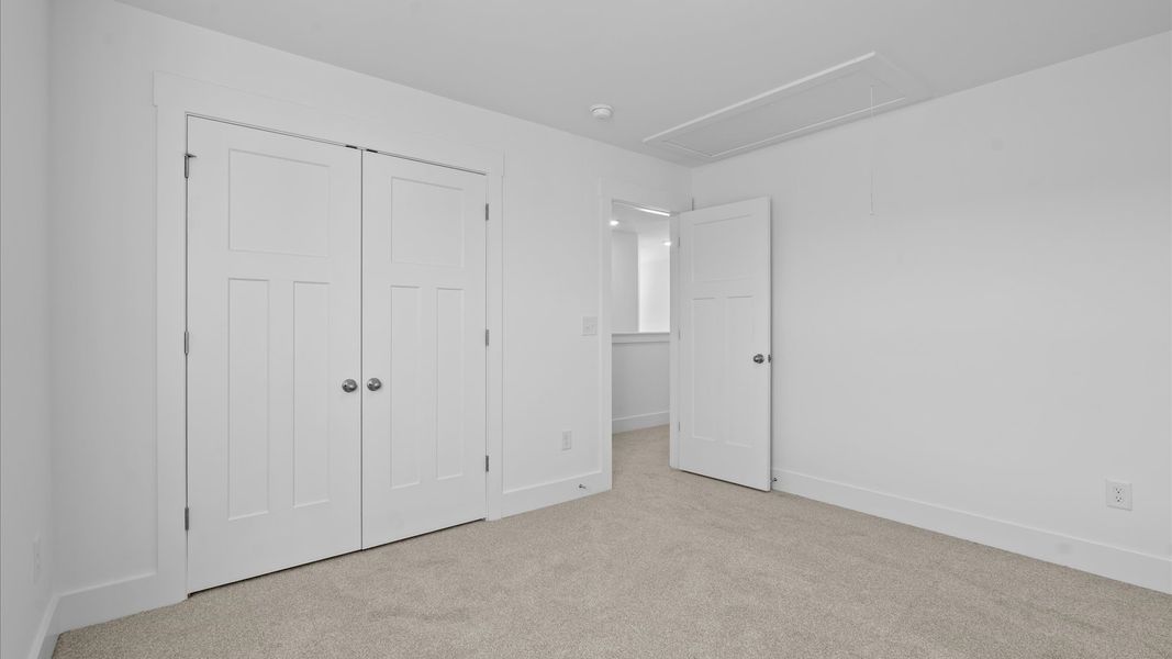 Accomplished design in this restful bedroom featuring plush carpet and oversized window views