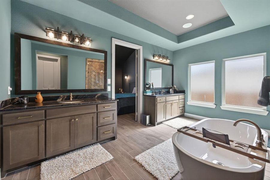 Spa-inspired bath with freestanding tub and dual granite vanities. Spa-inspired bath with freestanding tub and dual granite vanities.