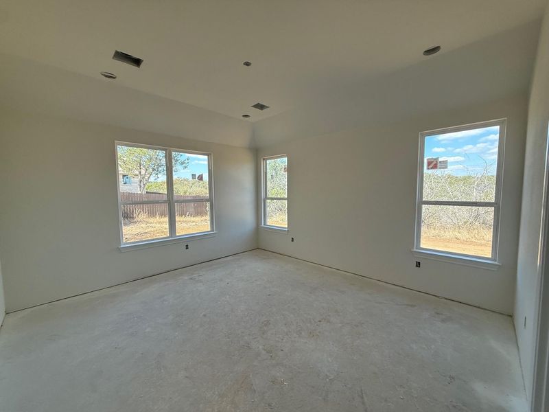 Unfurnished room featuring healthy amount of natural light and unfinished concrete flooring