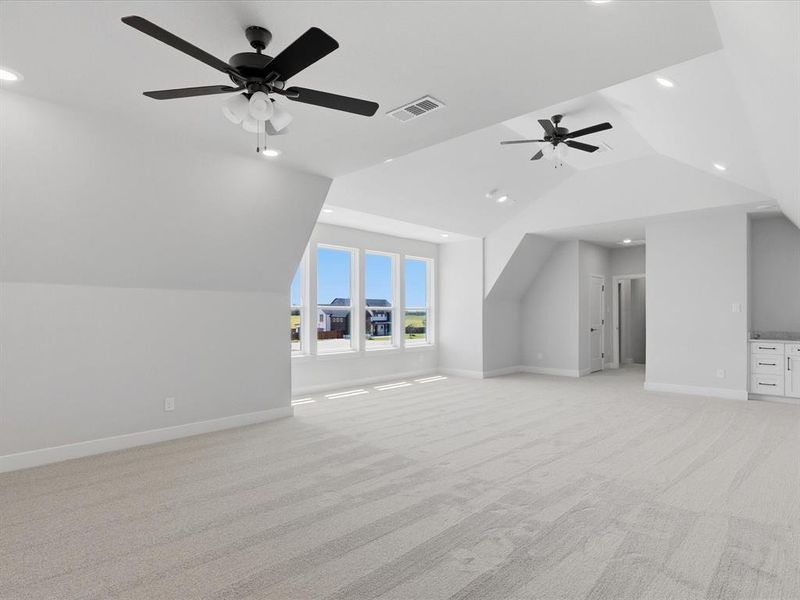 Spacious bonus room featuring light-toned carpeting, multiple windows, recessed lighting, and dual ceiling fans