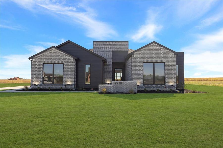 Contemporary home featuring brick siding and a front lawn Contemporary home featuring brick siding and a front lawn