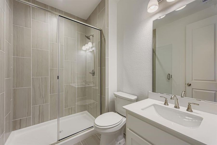 Bathroom with vanity, a textured wall, and a stall shower Bathroom with vanity, a textured wall, and a stall shower