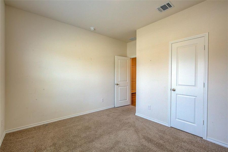 Unfurnished bedroom with carpet flooring and baseboards