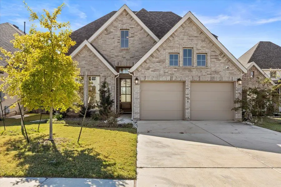 View of front facade featuring brick siding, a shingled roof, a front lawn, and driveway View of front facade featuring brick siding, a shingled roof, a front lawn, and driveway