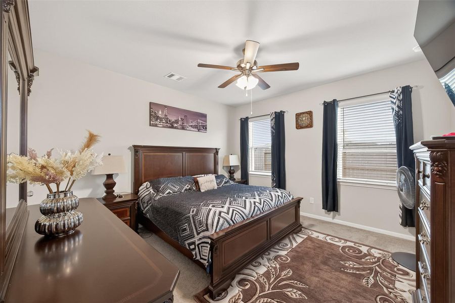 This primary bedroom is a true getaway, offering plenty of square footage for large furniture and a sunny, upbeat vibe.