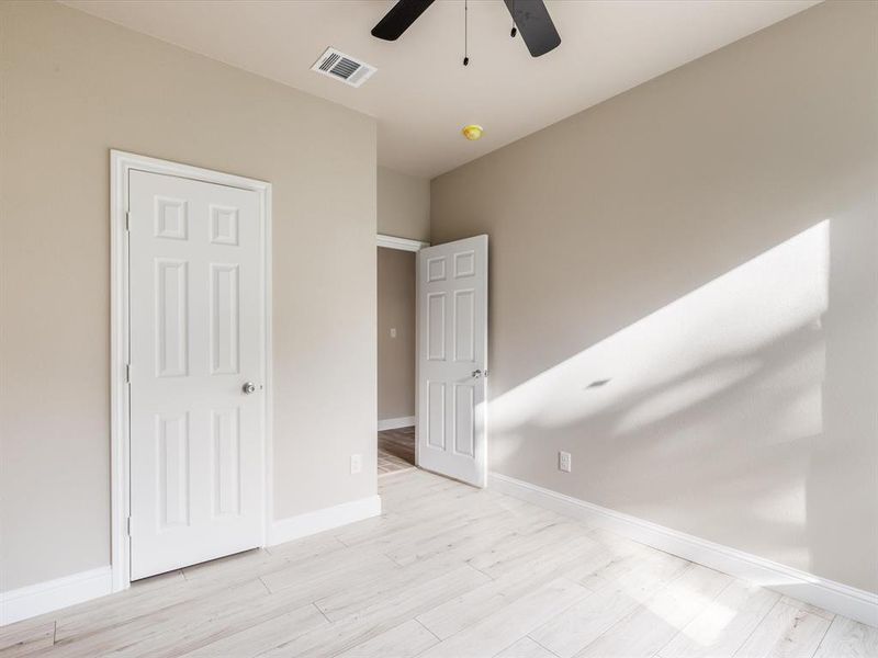 Unfurnished bedroom with light wood-type flooring and ceiling fan Unfurnished bedroom with light wood-type flooring and ceiling fan