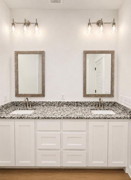 Double vanity featuring white shaker-style cabinetry and granite countertops Double vanity featuring white shaker-style cabinetry and granite countertops