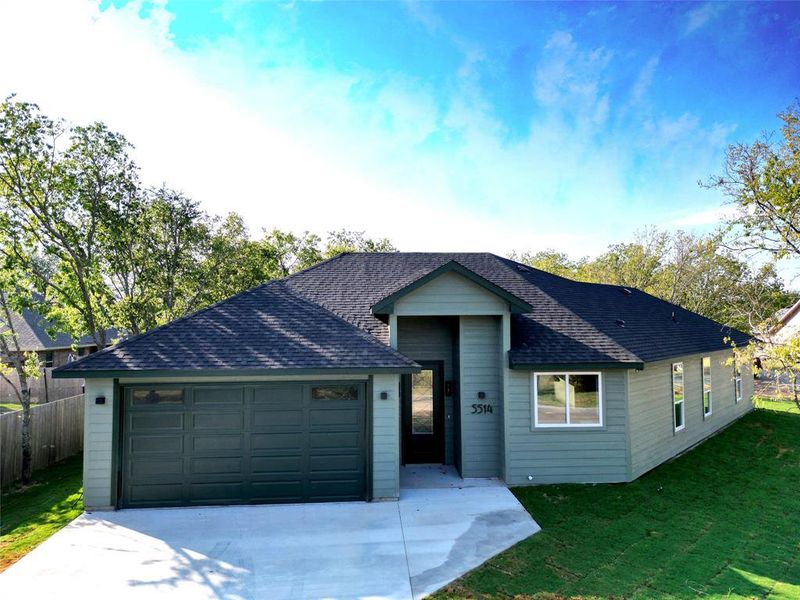 Ranch-style house featuring a front lawn and a garage